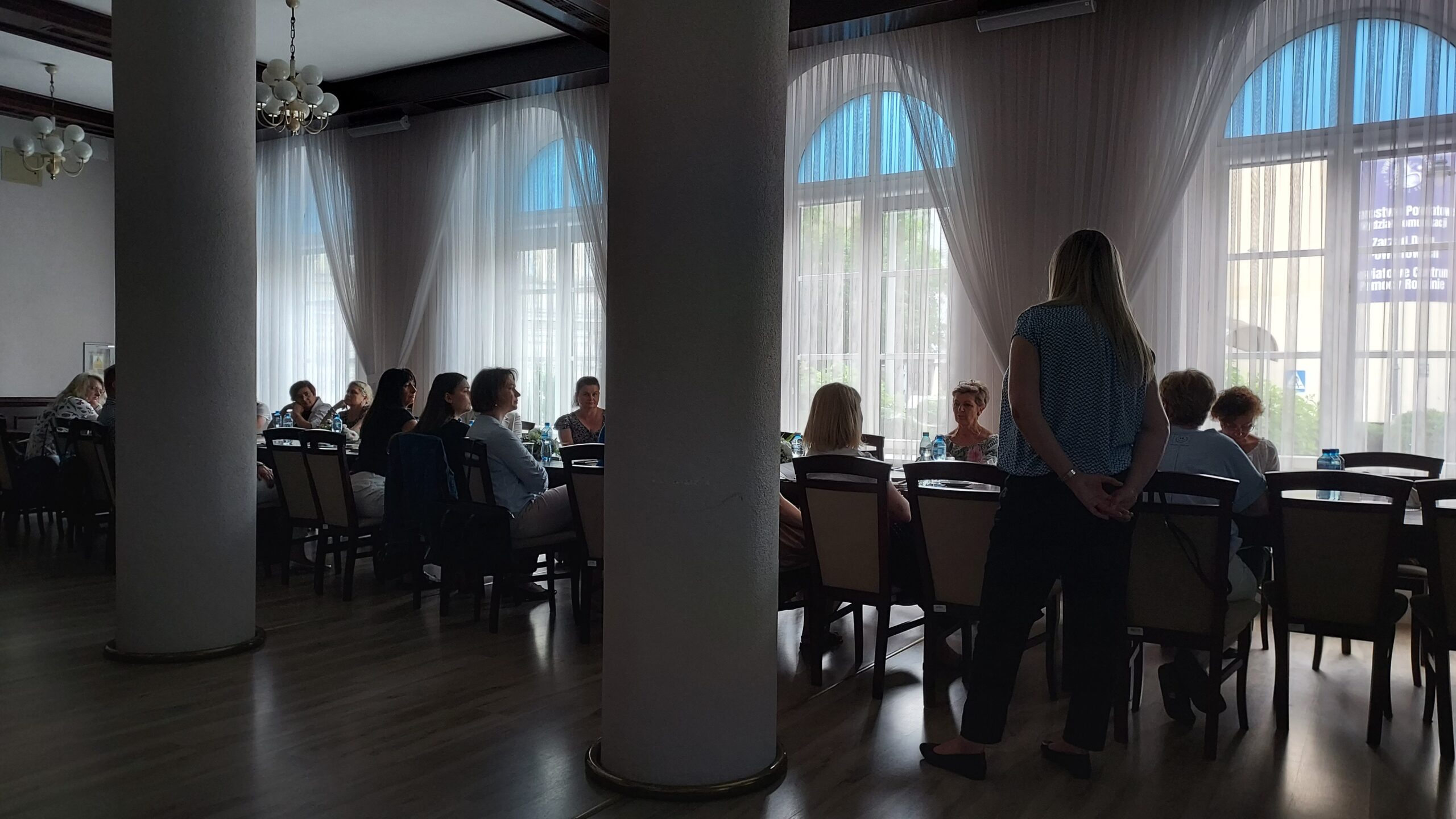 uczestnicy szkolenia siedzący przy stolikach