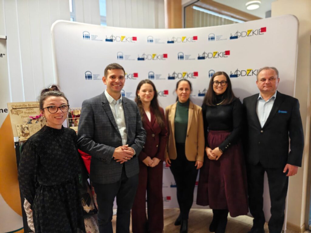 3.	Ludzie zgromadzeni przed dużym banerem, wyrażają radość i entuzjazm.  