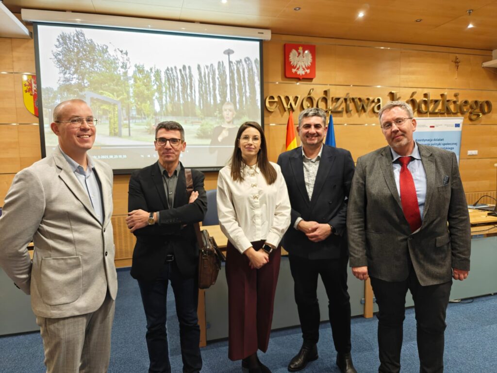 8.	Grupa ludzi stoi przed ekranem, angażując się w prezentację lub dyskusję.  