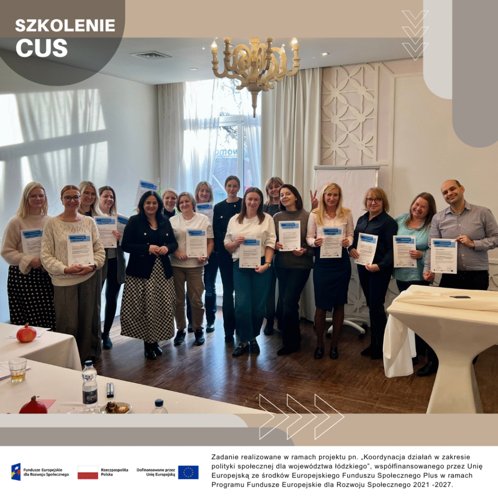 Grupa osób uczestniczących w szkoleniu CUS stoi w sali szkoleniowej, trzymając w rękach certyfikaty. W tle widać jasne zasłony, lampę i elementy wystroju sali.