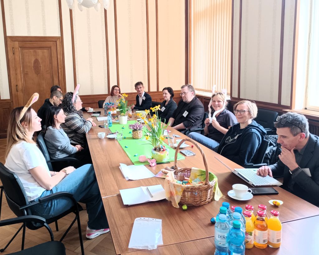 Stół otoczony przez ludzi, którzy cieszą się napojami i wspólną rozmową