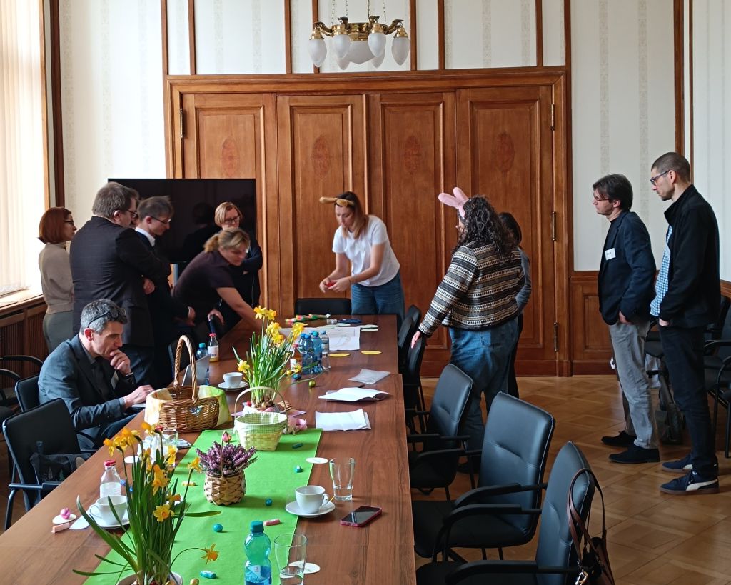 Ludzie stoją przy stole, angażując się w rozmowę