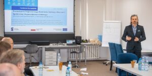 Mężczyzna prowadzi prezentację przed grupą słuchaczy