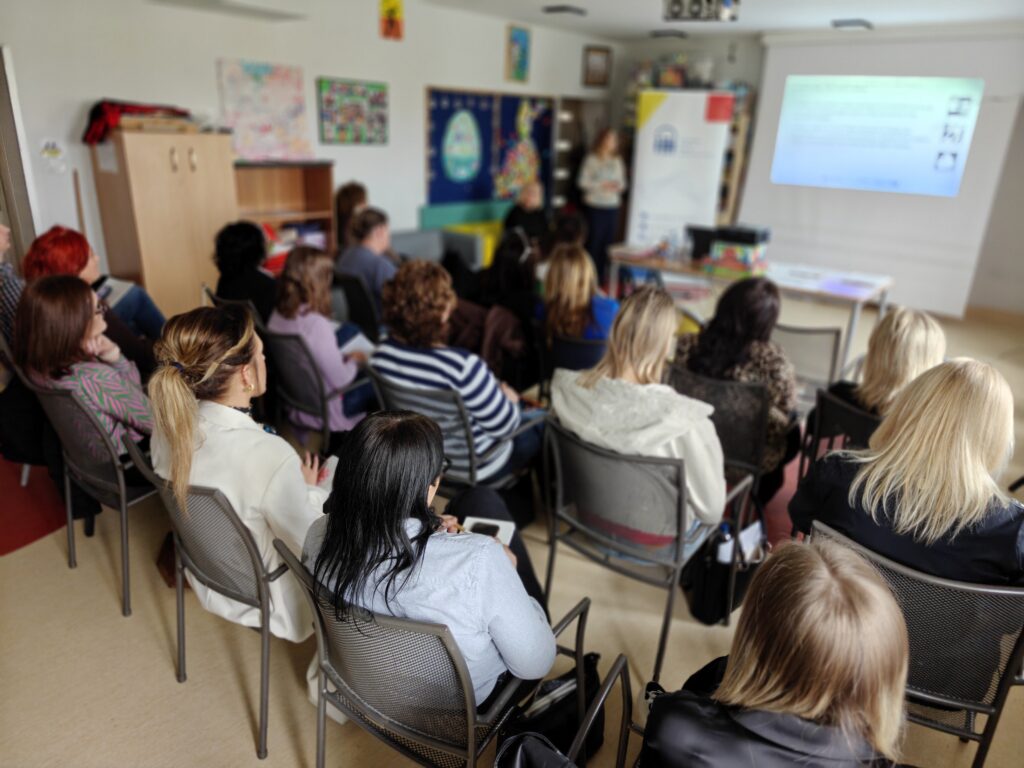 grupa uczestniczek wsłuchanych w osobę prowadzącą