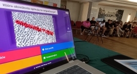 Laptop z dużym ekranem, wyświetlający różne aplikacje i dokumenty na jasnym tle