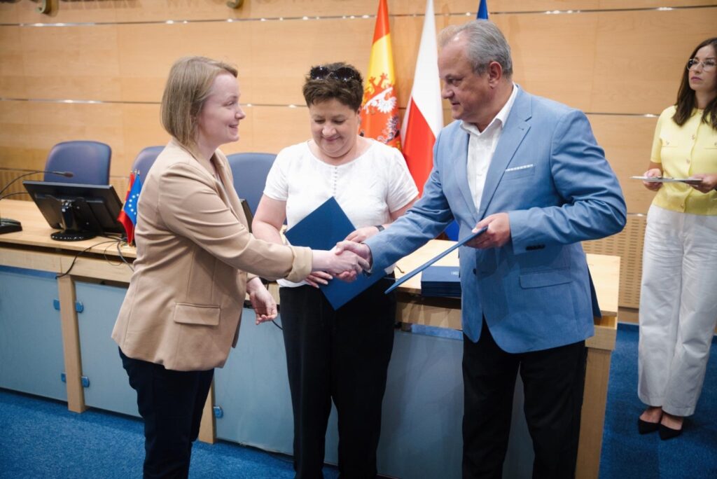 Mężczyzna i kobieta uściski dłoni przed stołem, symbolizując powołanie do składu gremium