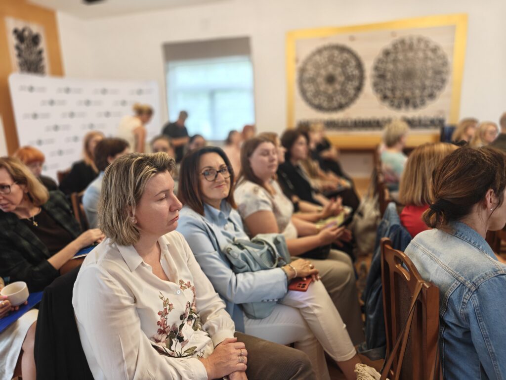 grupa siedzących osób na sali wykładowej